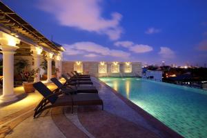 a swimming pool on the roof of a building at night at Chillax Resort in Bangkok