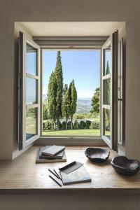 Cette chambre dispose d'une fenêtre avec des livres sur une table. dans l'établissement Badia di Pomaio, à Arezzo