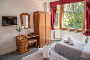 a bedroom with a bed and a desk with a mirror at Crystal Hotel & Savour in Cambridge