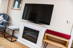 a living room with a tv on top of a fireplace at Central Durham Riverfront Apartment in Durham