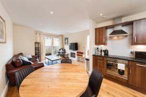 a kitchen and living room with a wooden table at Central Durham Riverfront Apartment in Durham