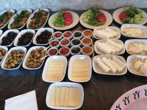 uma mesa coberta com bandejas de diferentes tipos de alimentos em EM-BA BUTİK BUNGALOV em Demre