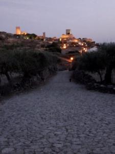 un camino de piedra con una ciudad en el fondo por la noche en Casa das Freiras, en Marialva