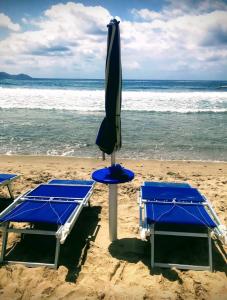 twee bedden en een parasol op het strand bij H24 Vacanze in Villanova Monteleone