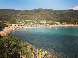 a beach with a bunch of people in the water at H24 Vacanze in Villanova Monteleone