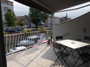 a patio with a table and chairs on a balcony at La Maison Lydia in Moissac