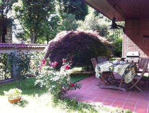 una mesa y sillas en un patio con flores en Villa Camilla, en Monza