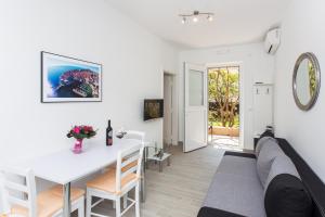 ein Wohnzimmer mit einem weißen Tisch und einem Sofa in der Unterkunft Apartments L&M in Dubrovnik