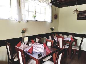 a dining room with tables and chairs with red napkins at Čertovka Peklo in Náchod
