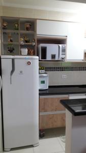 a kitchen with a white refrigerator and a microwave at Mar Azul in Solemar