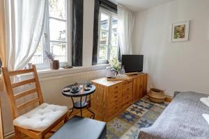 a room with a bed and a television and a table at An der Gose - Gästezimmer & Appartement in Goslar