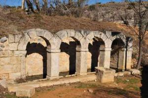 un antiguo edificio de piedra con arcos en una colina en Casa Rural La Posada Del Frances, en Villarrubia de Santiago