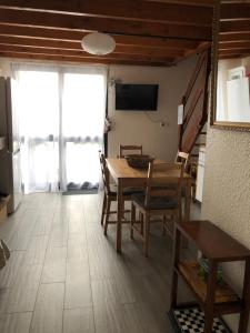 a dining room with a table and chairs and a television at Cottage à Cabourg in Cabourg