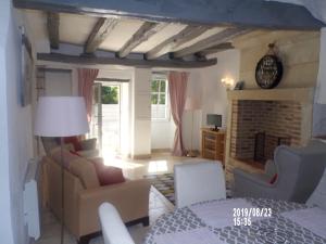 sala de estar con muebles y chimenea en Le Troglo des Renaudières, en Azay-le-Rideau