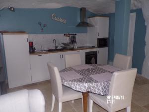 cocina con mesa y sillas y cocina con encimera en Le Troglo des Renaudières, en Azay-le-Rideau