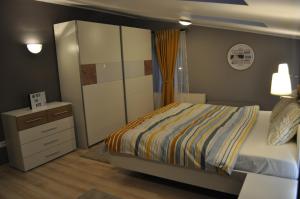 a small bedroom with a bed and a dresser at Sleep & Fly Apartment in Otopeni