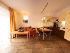 eine Küche und ein Wohnzimmer mit Sofa und Tisch in der Unterkunft Dolce Vita in Serfaus