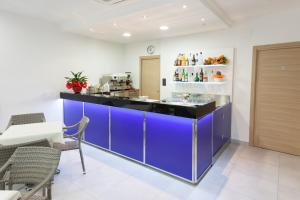 a kitchen with a blue counter and some chairs at Hotel Garden in Giulianova