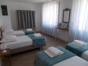 Habitación de hotel con 3 camas y espejo en La Maison Lydia en Moissac