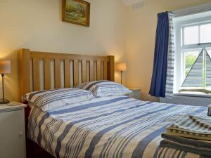 A bed or beds in a room at Coastguard Cottage 