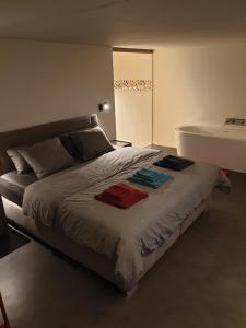 a bedroom with a large bed with towels on it at Le Repaire du Nez Rouge in Stavelot