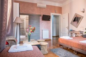 ローマにあるSesto Suites Centralのベッド2台とリビングルームが備わる客室です。