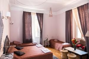 ローマにあるSesto Suites Centralのベッド2台とテーブルが備わるホテルルームです。