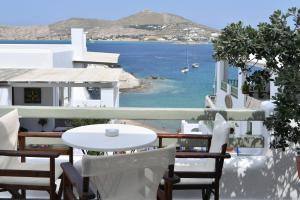 a table and chairs on a balcony with a view of the ocean at Hara Studios and Apartments in Naousa