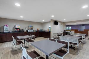 a restaurant with tables and chairs and a counter at Microtel Inn & Suites by Wyndham Philadelphia Airport in Philadelphia