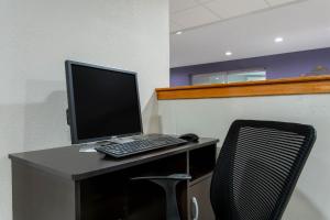 a desk with a computer monitor and a chair at Microtel Inn & Suites by Wyndham Philadelphia Airport in Philadelphia