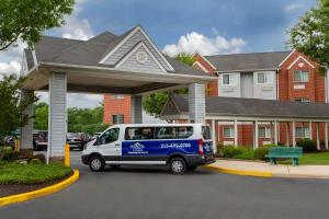 a blue and white van parked in front of a house at Microtel Inn & Suites by Wyndham Philadelphia Airport in Philadelphia