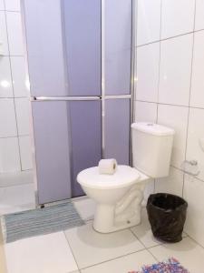 La salle de bains est pourvue d'une douche et de toilettes. dans l'établissement Pousada No Farol, à Tramandaí
