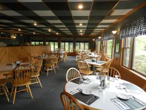 a dining room with tables and chairs and windows at C-Way Resort in Clayton