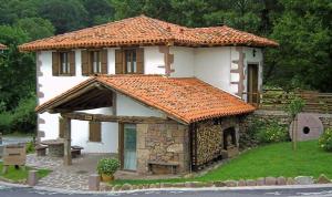 a small house with an orange tile roof at Amaiurko Errota in Maya del Baztán