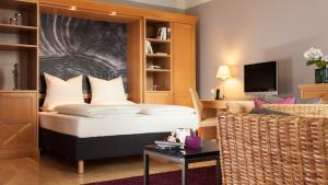 a bedroom with a bed and a living room at The Doorman Welle Frankfurt am Main in Frankfurt/Main