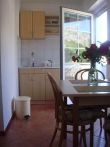 a kitchen with a table with a vase of flowers on it at Apartments Villa Andreja in Starigrad +90 photos