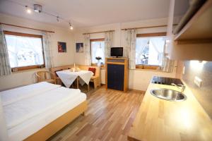 1 dormitorio con 1 cama y lavamanos y cocina en Landhaus Gudrun, en Tux 35 fotos más