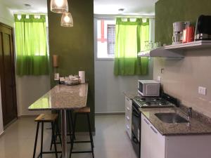 eine Küche mit grünen Vorhängen und einer Arbeitsplatte in der Unterkunft San Telmo Vivo in Buenos Aires