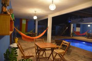 een patio met een tafel en stoelen naast een zwembad bij Pousada Amigos do Vento in Touros