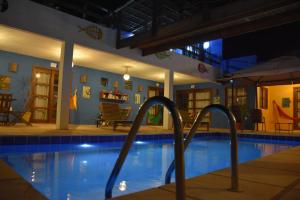 una piscina por la noche con un complejo con alfabetizador en Pousada Amigos do Vento en Touros