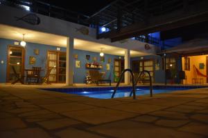 an empty swimming pool at night with a resort at Pousada Amigos do Vento in Touros