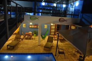 a room with a pool and chairs and a basketball hoop at Pousada Costa Prestige in Touros