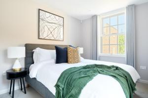 ein Schlafzimmer mit einem Bett mit einer grünen Decke darauf in der Unterkunft Sonder Sloane Square in London
