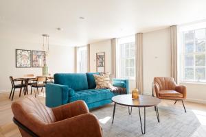 ein Wohnzimmer mit einem blauen Sofa und Stühlen in der Unterkunft Sonder Sloane Square in London