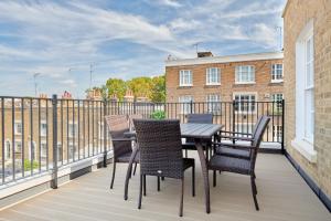 eine Terrasse mit einem Tisch und Stühlen auf dem Balkon in der Unterkunft Sonder Sloane Square in London