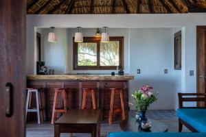 a kitchen with a bar with stools and a table at Casa Kalmar in Zipolite