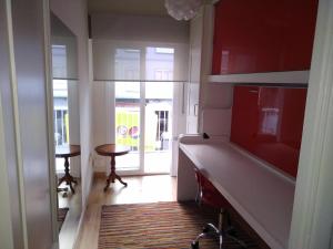 a kitchen with red walls and a hallway with a table at YEDRA in Ourense