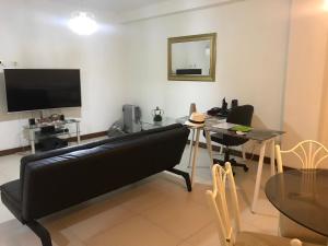 Una sala de estar con un sofá negro y una mesa. en Edificio California en Centro Historico, en Lima
