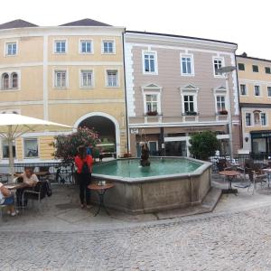 a woman standing in front of a fountain in a courtyard at Marktplatz Traunsee LAKE View in Gmunden