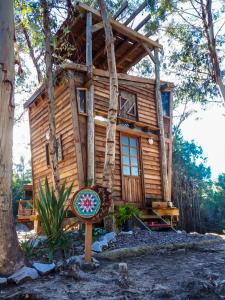 una cabaña de madera con un cartel delante en Flor de Vida Geocabañas - Tiny, en La Esmeralda